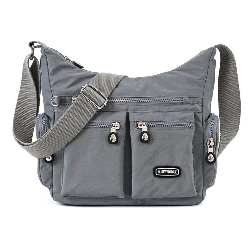 Gray shoulder bag with multiple pockets and a visible brand label on a white background