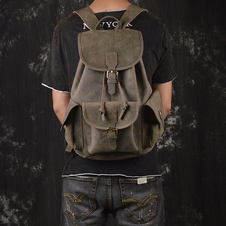 Person wearing a green backpack against a dark background