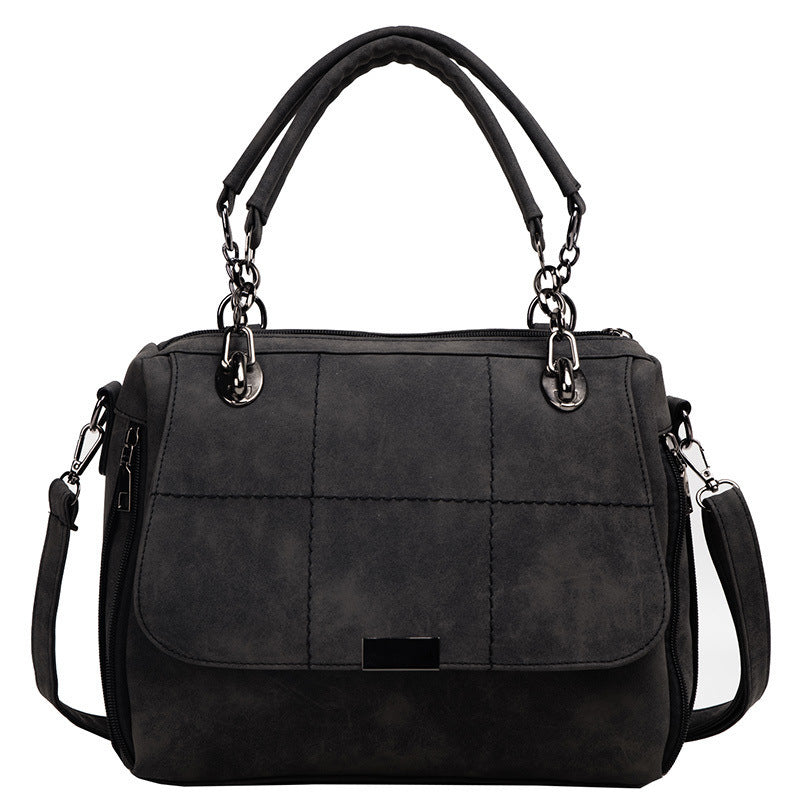 Black handbag with quilted design on a white background