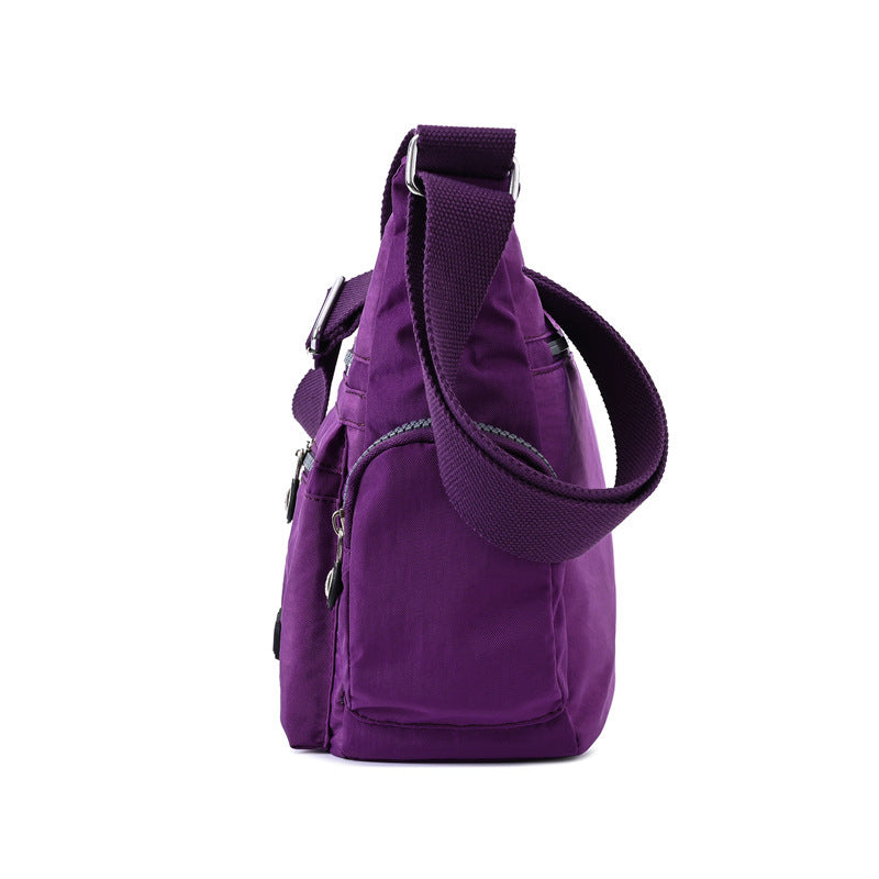 Purple backpack with a shoulder strap on a white background