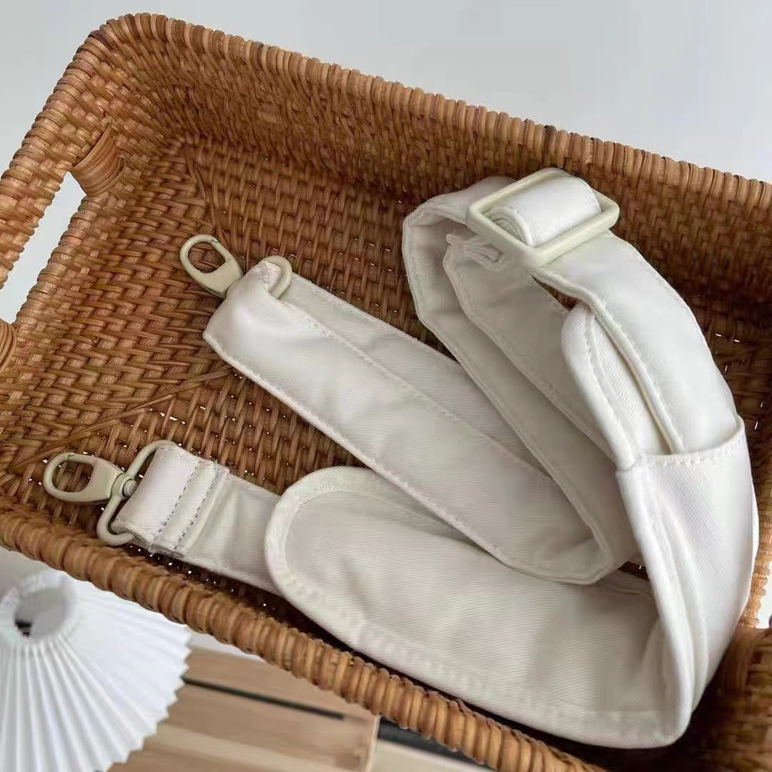 White strap with beige buckles on a woven basket