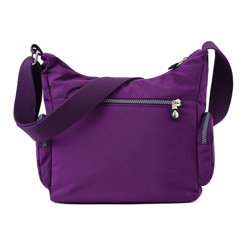 Purple shoulder bag with zippers on a white background