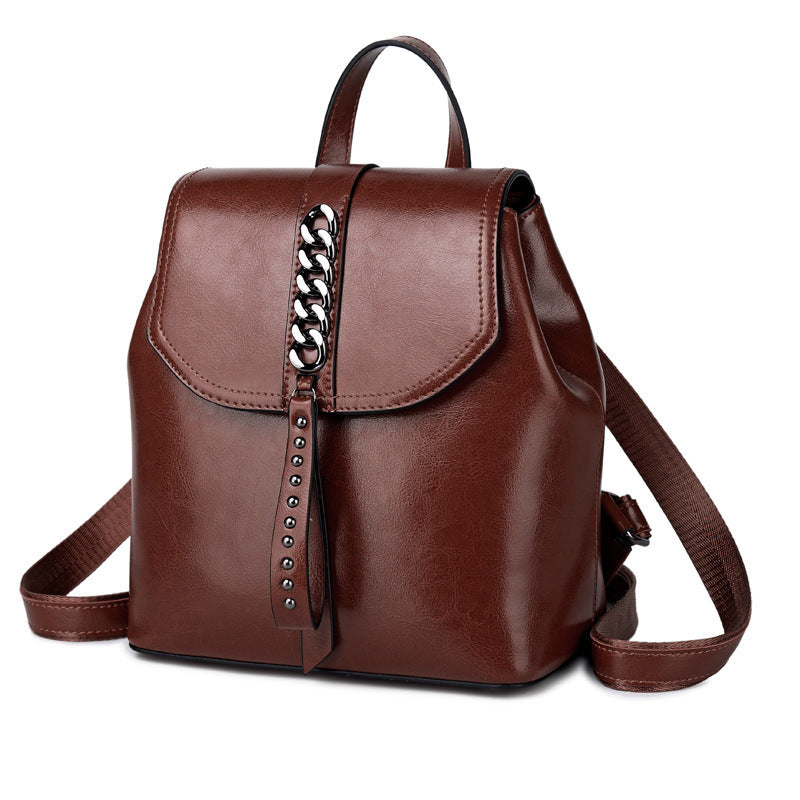 Brown leather backpack with chain detail on a white background