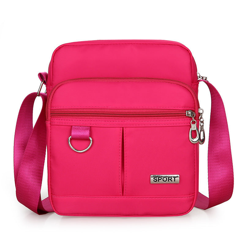 Pink crossbody bag with 'SPORT' label on a white background