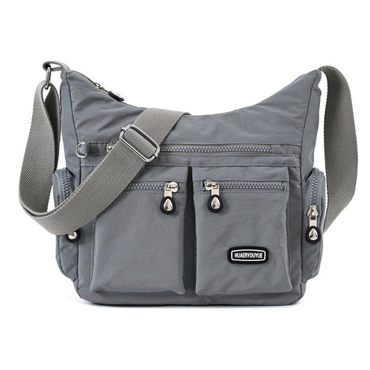 Gray shoulder bag with multiple pockets and a visible brand label on a white background