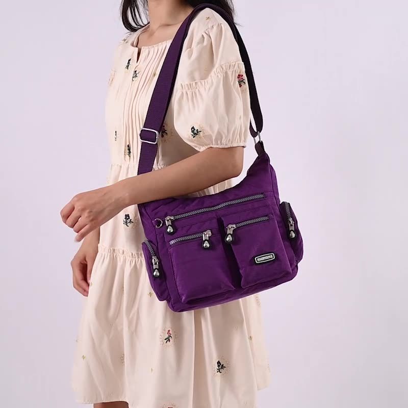 Person wearing a purple shoulder bag on a plain background