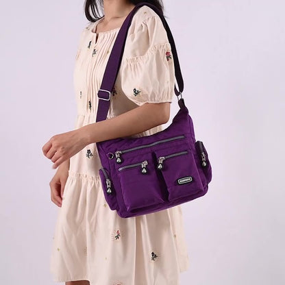 Person wearing a purple shoulder bag on a plain background
