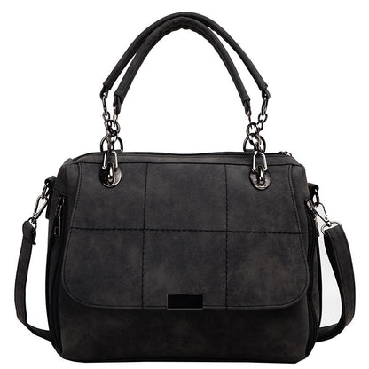 Black handbag with quilted design on a white background