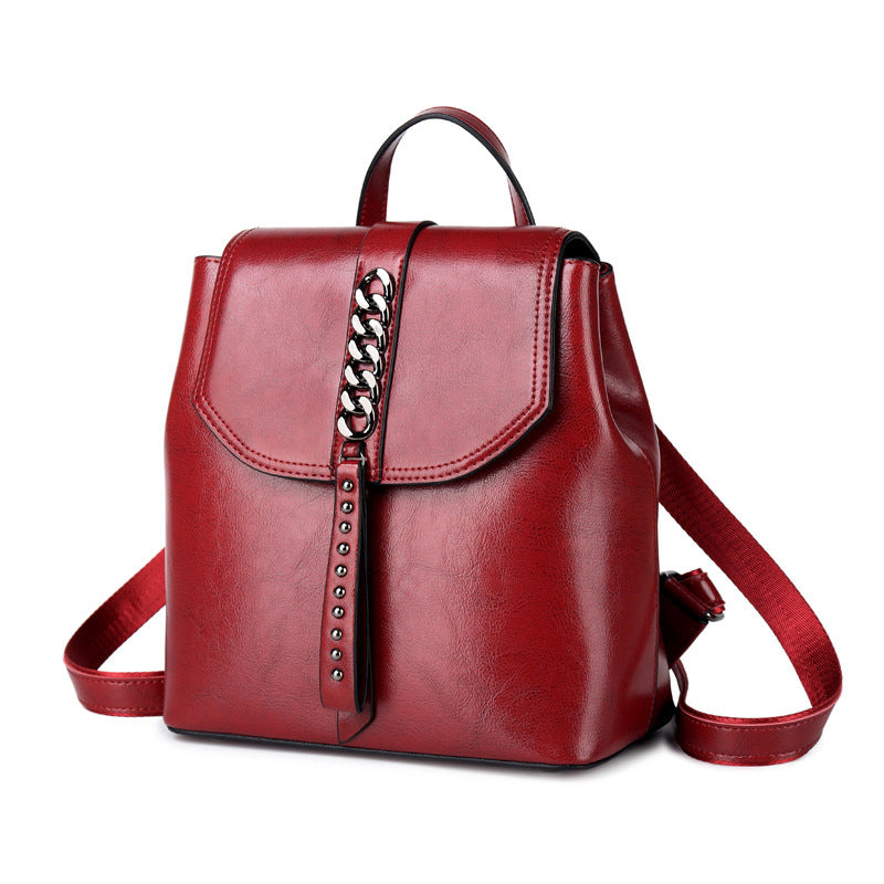 Red backpack with a chain detail on a white background