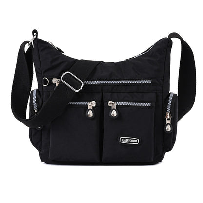Black shoulder bag with silver zippers on a white background