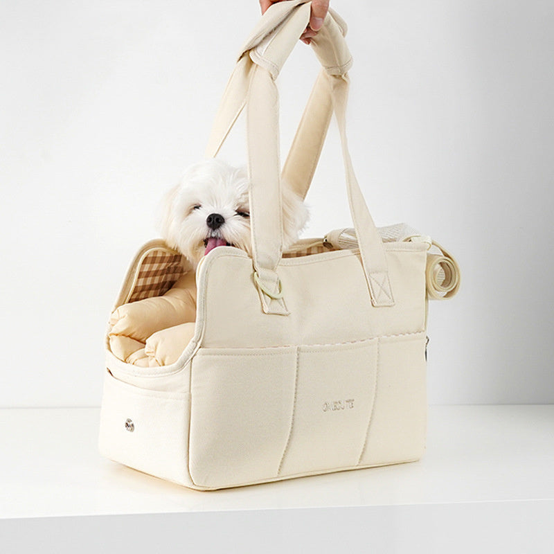 White dog in a beige pet carrier with a checkered pillow on a white background