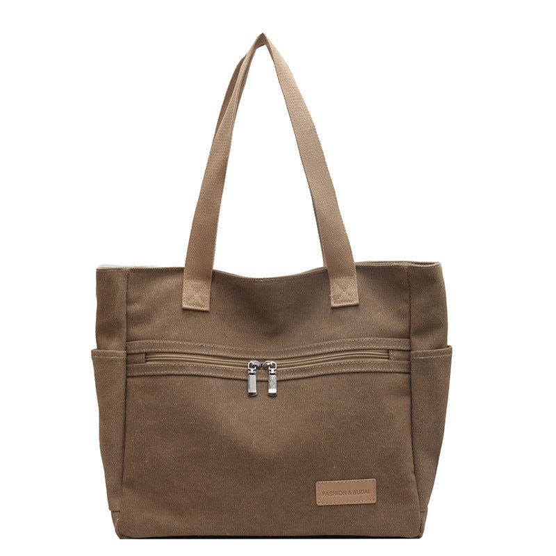 Brown tote bag with zippers on a white background