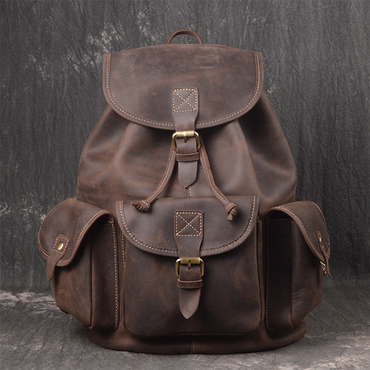 Brown leather backpack on a dark textured background