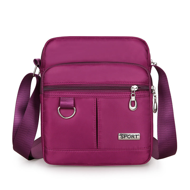 Purple crossbody bag with 'SPORT' label on a white background