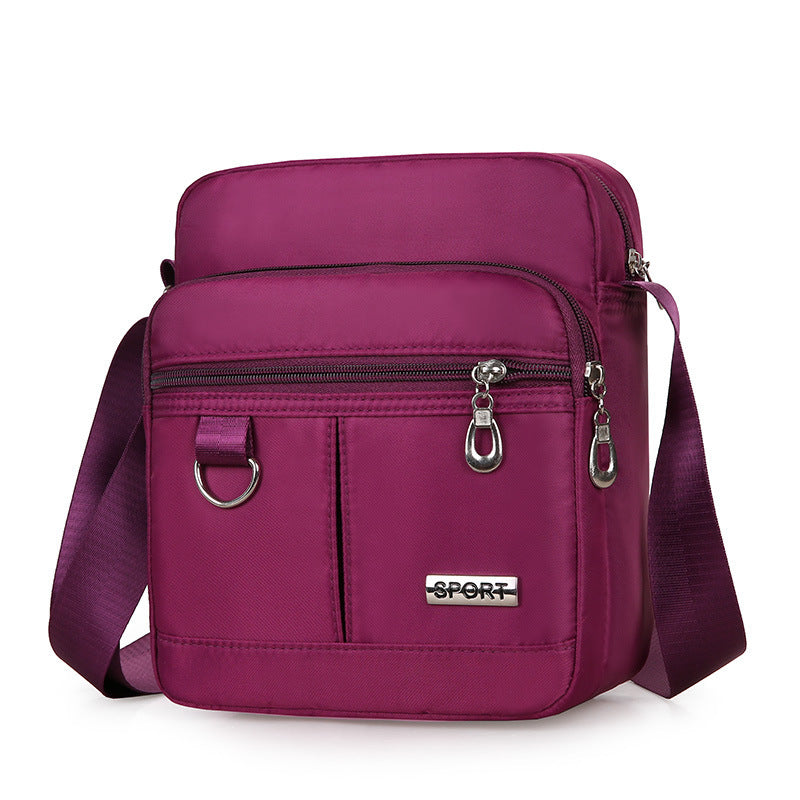 Purple crossbody bag with 'SPORT' label on a white background