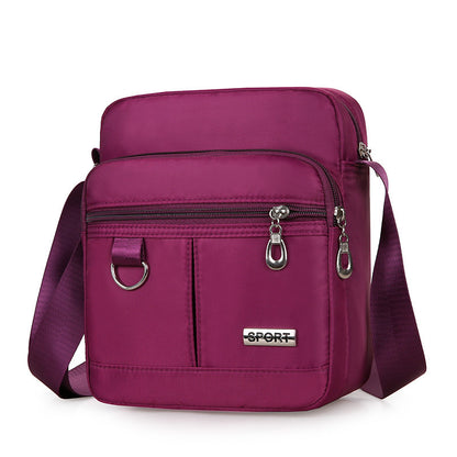 Purple crossbody bag with 'SPORT' label on a white background