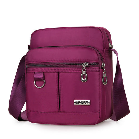 Purple crossbody bag with 'SPORT' label on a white background
