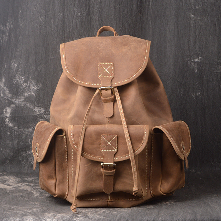 Brown leather backpack on a dark textured background