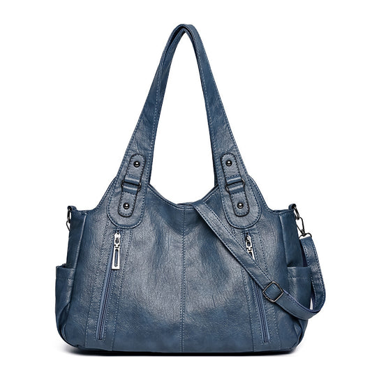 Blue handbag with multiple pockets and straps on a white background