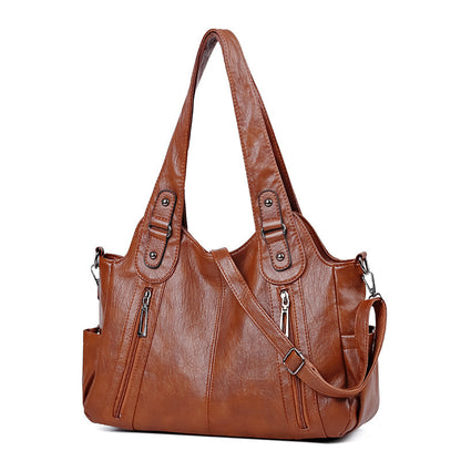 Brown leather handbag with shoulder strap on a white background