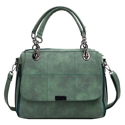 Green handbag with quilted design on a white background