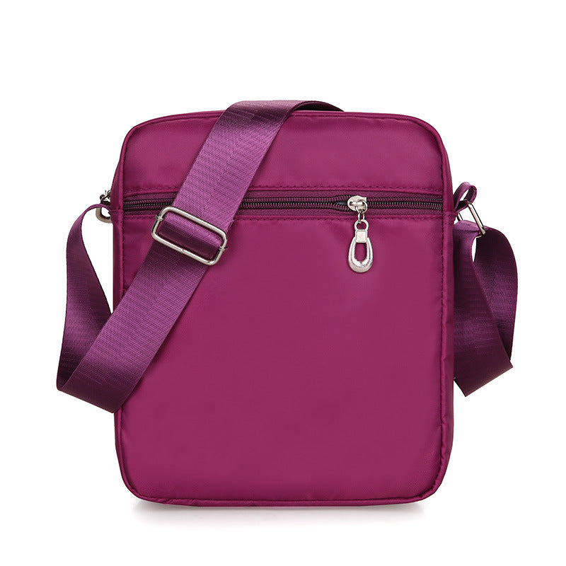 Purple shoulder bag with a strap on a white background