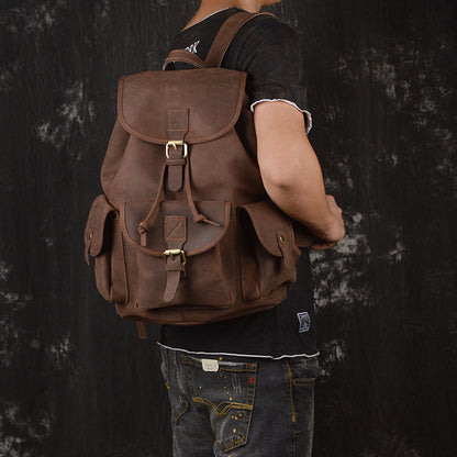 Person wearing a brown leather backpack against a dark background