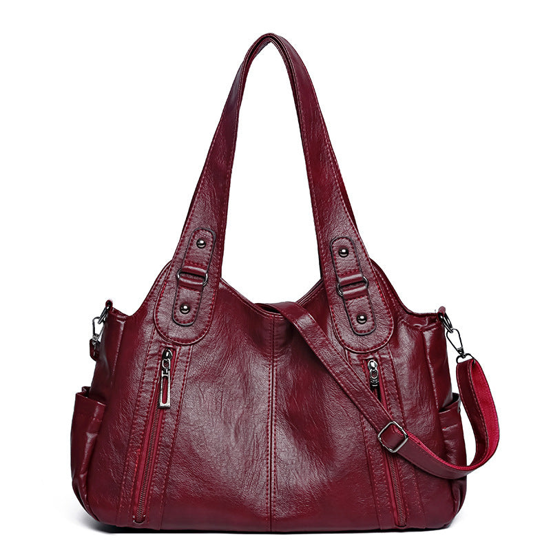Red handbag with a shoulder strap on a white background