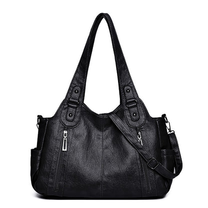 Black handbag with multiple pockets and zippers on a white background