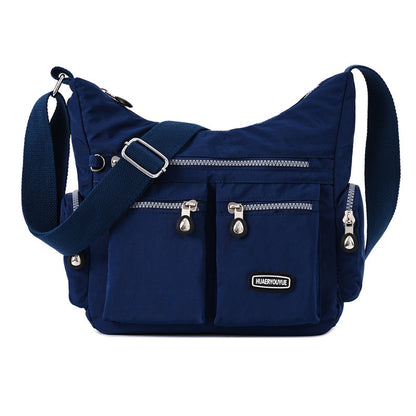 Blue shoulder bag with silver zippers and a visible brand logo on a white background
