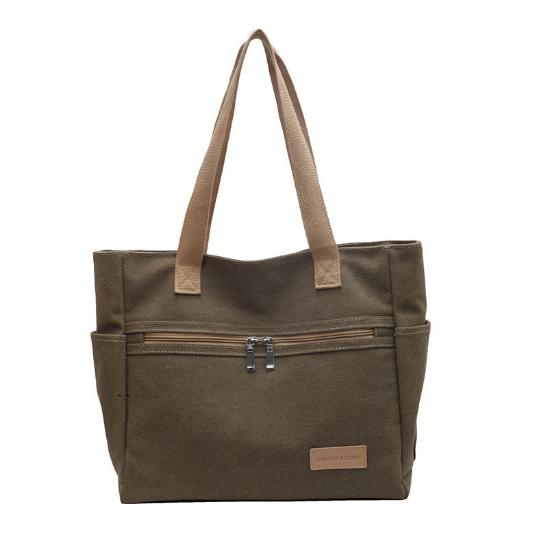 Brown tote bag with zippers on a white background