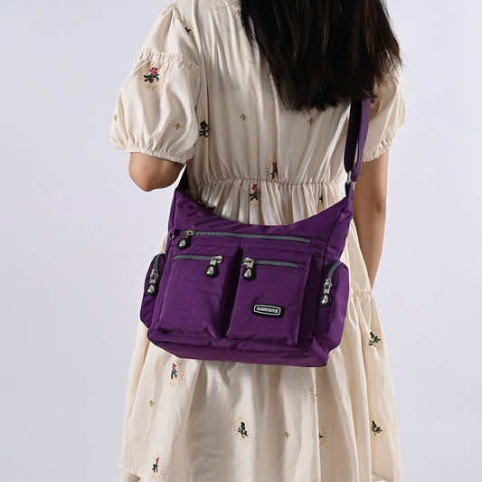 Person wearing a purple backpack on a plain background