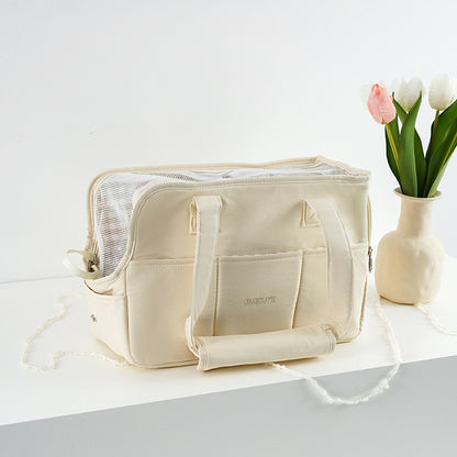 Beige toiletry bag on a white surface with a vase of tulips in the background