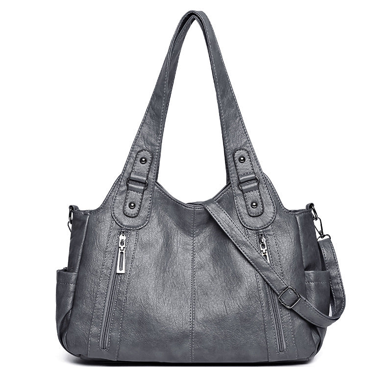 Gray handbag with multiple pockets and straps on a white background