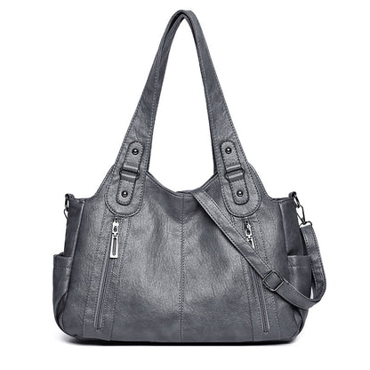 Gray handbag with multiple pockets and straps on a white background