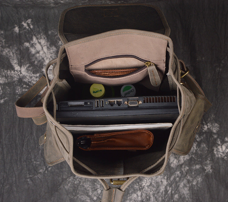 Open bag with laptop and items on a textured gray background