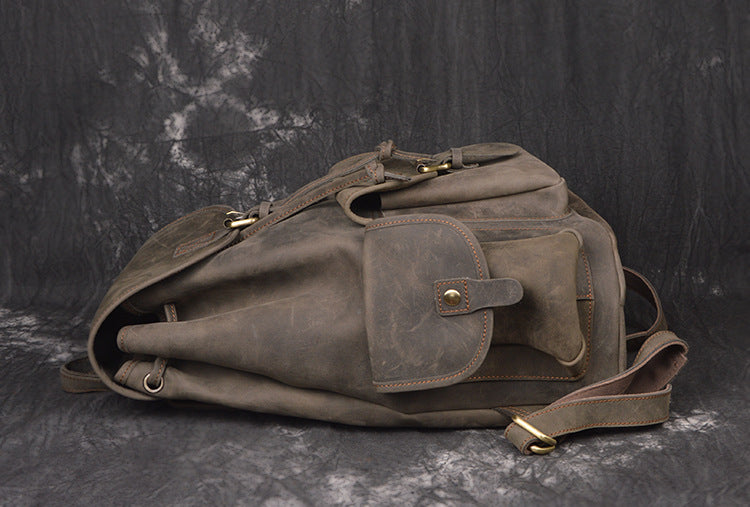 Brown leather bag with gold hardware on a dark textured background