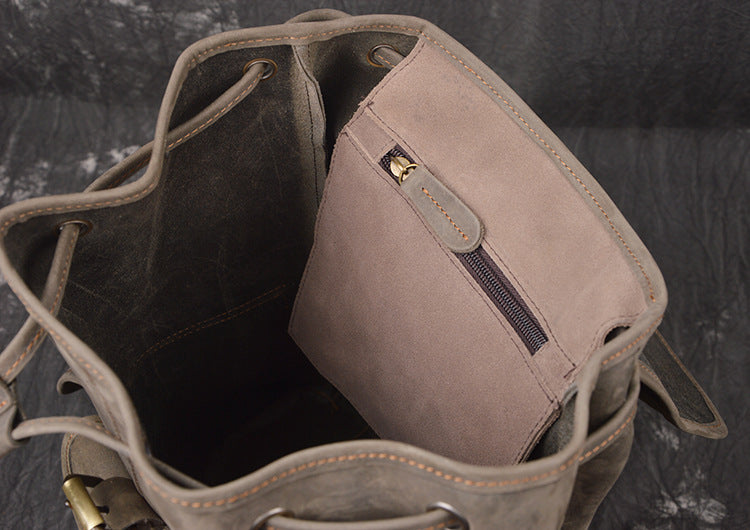Beige leather bag with a zipper pocket on a dark textured background