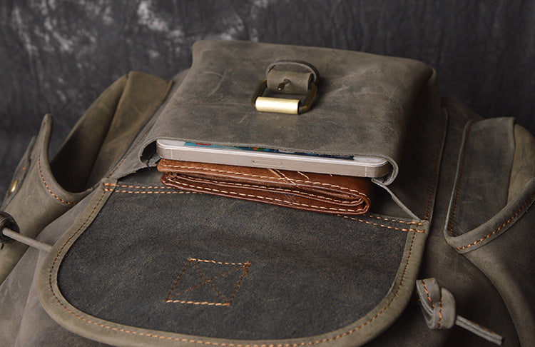 Brown leather bag with a compartment for a smartphone on a dark background