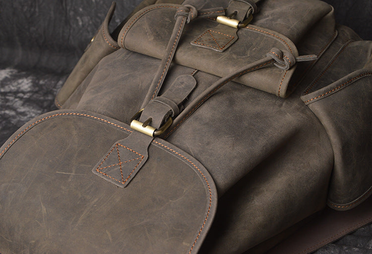 Brown leather bag with gold buckles on a dark background
