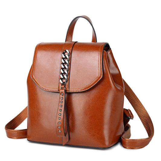 Brown leather backpack with chain detail on a white background