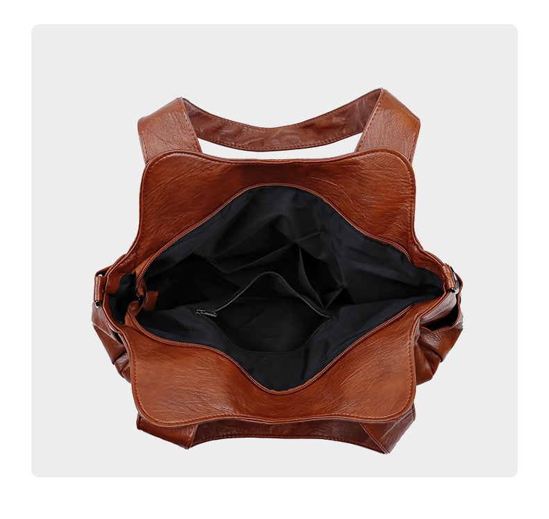 Brown leather bag with open front on a white background