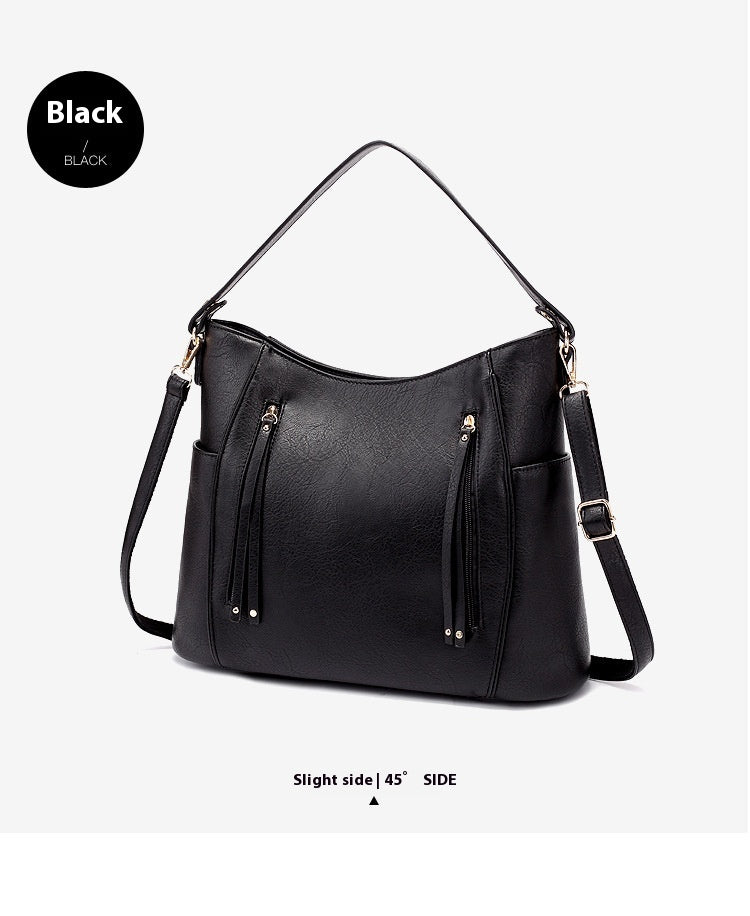 Black handbag with gold accents on a light gray background
