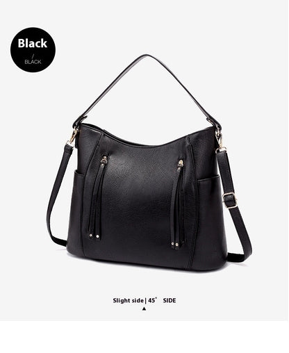 Black handbag with gold accents on a light gray background